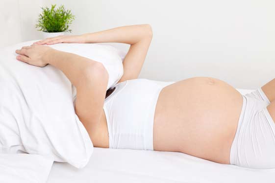Zeigt eine Frau im Bett mit Schlafprobleme-in-der-Schwangerschaft